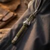 Dragonne vert armée fixée à la fermeture éclair d'une veste technique